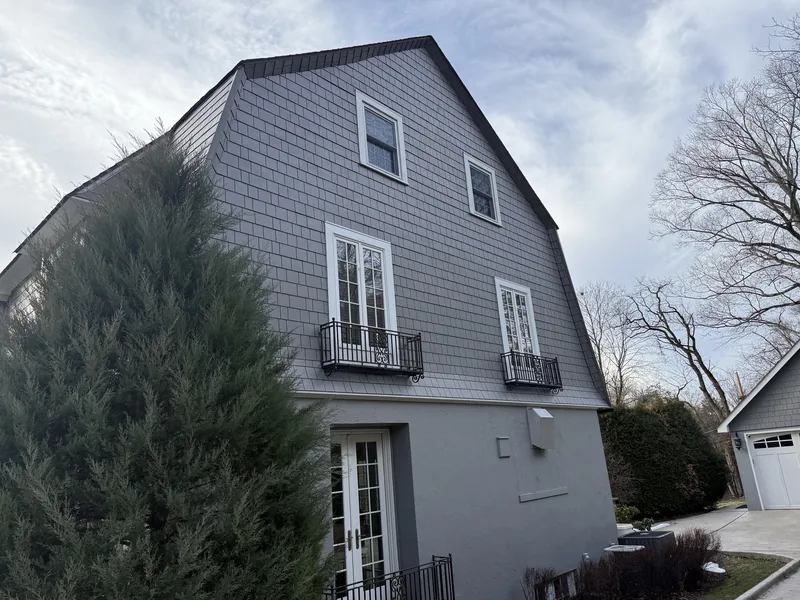 Gambrel end wall of the same Sewickley home, showing the two roof pitches meeting the Hardie shingle siding